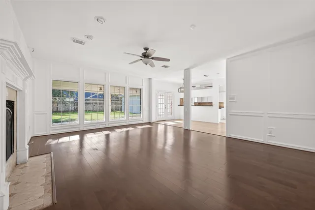 an empty room with windows and fireplace