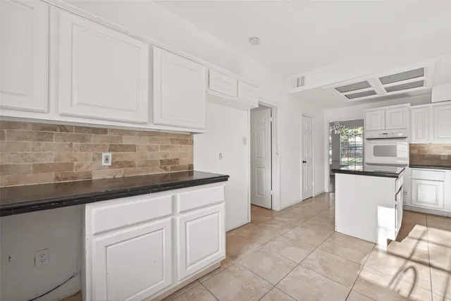 an empty room with wooden floor and fan