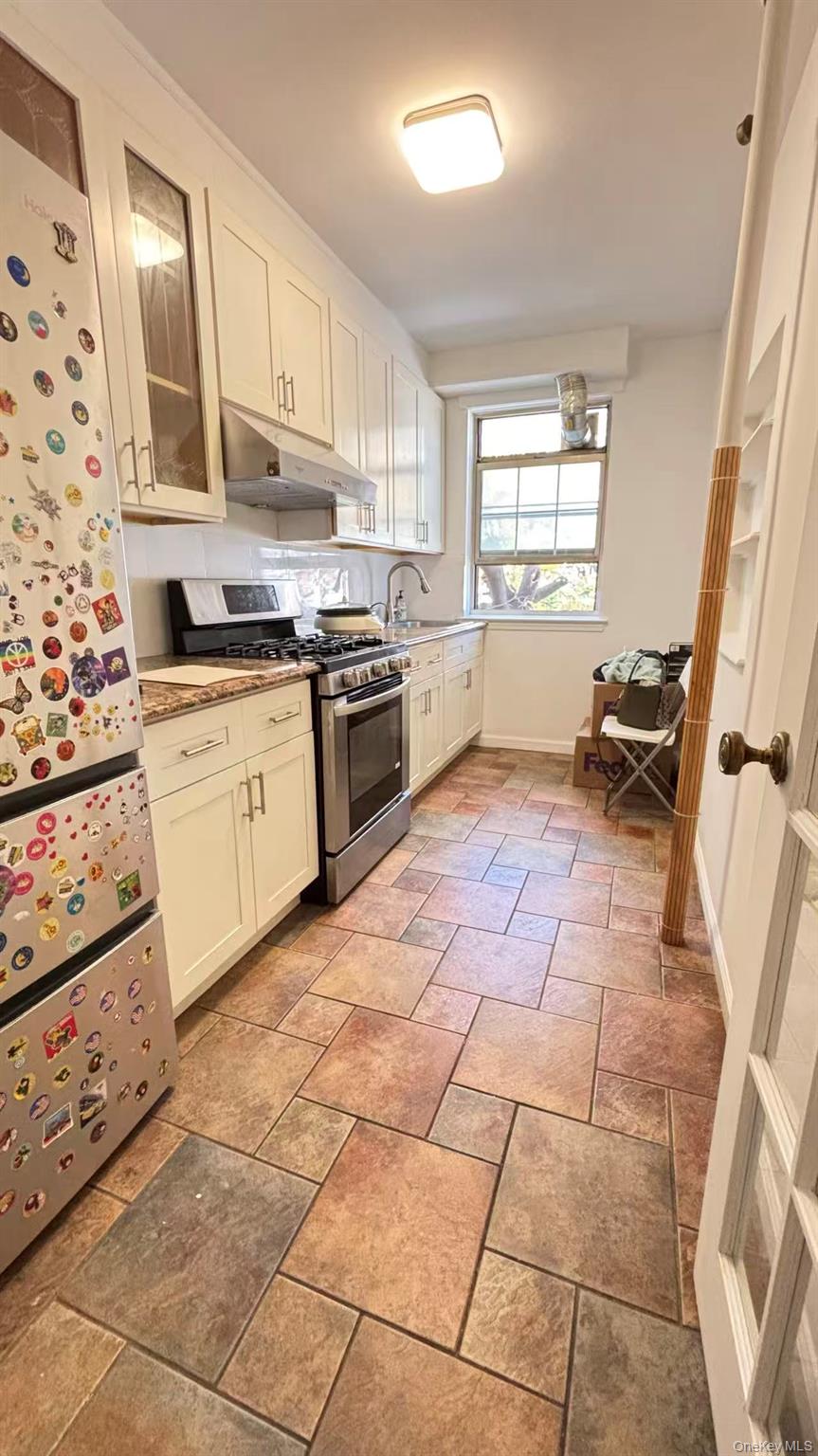13806 78th Avenue, Unit 37D Queens, NY 11367 - Photo 3 of 11 a kitchen with stainless steel appliances granite countertop a stove a sink and a refrigerator