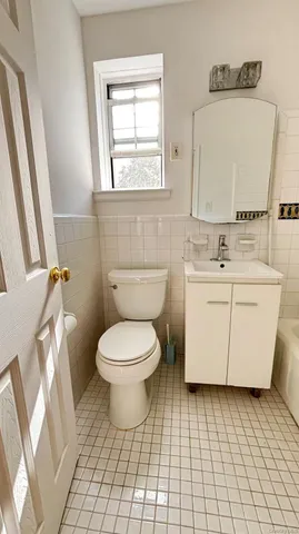 a bathroom with a toilet sink and mirror
