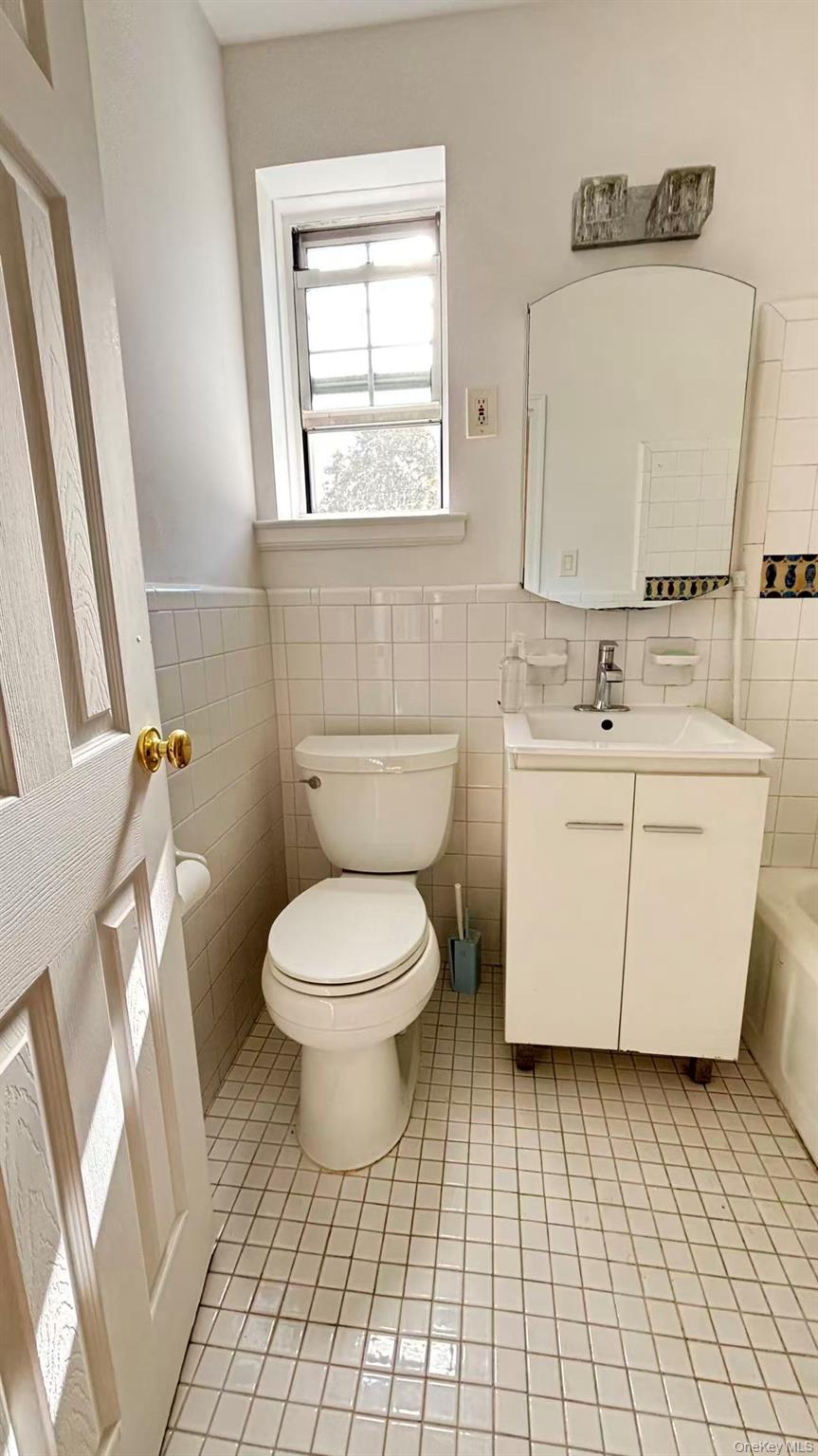 13806 78th Avenue, Unit 37D Queens, NY 11367 - Photo 8 of 11 a bathroom with a toilet sink and mirror