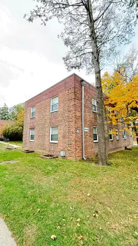 a large house with a big yard and large trees