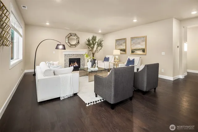 a living room with furniture a fireplace and wooden floor