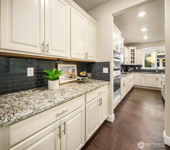 a kitchen with granite countertop white cabinets and white appliances