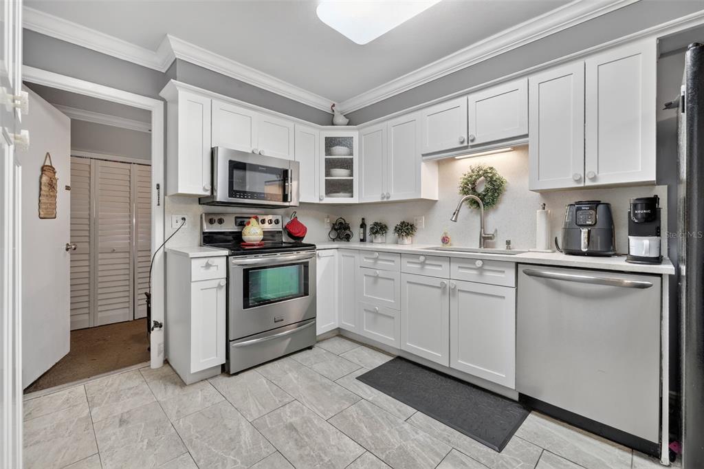 575 Tiberon Cove Road Longwood, FL 32750 - Photo 23 of 56 a kitchen with granite countertop white cabinets and white appliances
