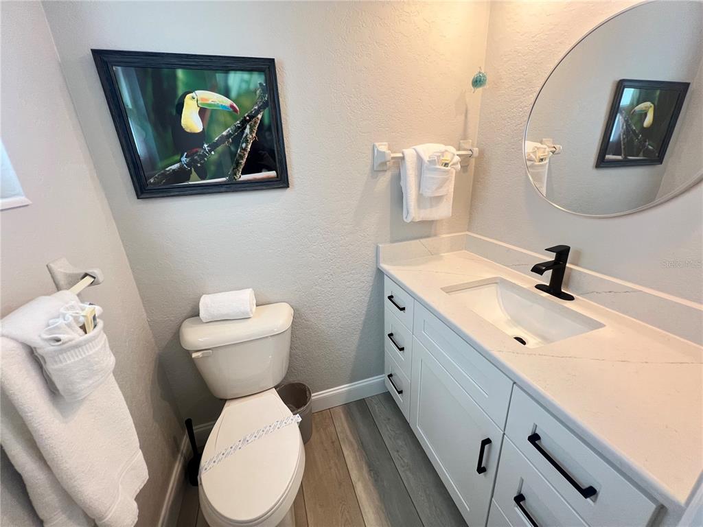 6154 Midnight Pass Road, Unit D02 Sarasota, FL 34242 - Photo 9 of 12 a bathroom with a toilet a sink and mirror