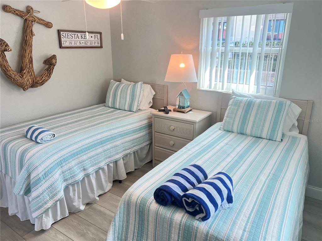 6154 Midnight Pass Road, Unit D02 Sarasota, FL 34242 - Photo 10 of 12 a bedroom with two beds and a large window
