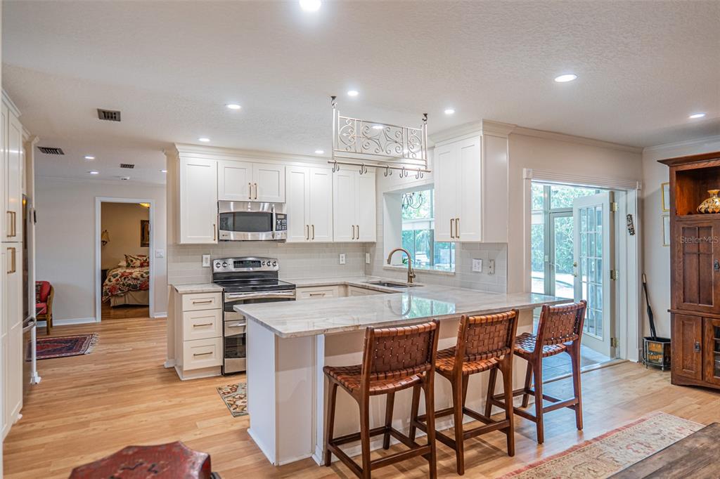 741 Brookside Road Maitland, FL 32751 - Photo 8 of 43 a kitchen with stainless steel appliances kitchen island granite countertop a stove a sink a refrigerator and a island