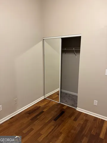 an empty room with wooden floor and closet