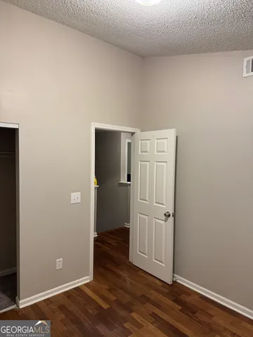 an empty room with wooden floor and closet area
