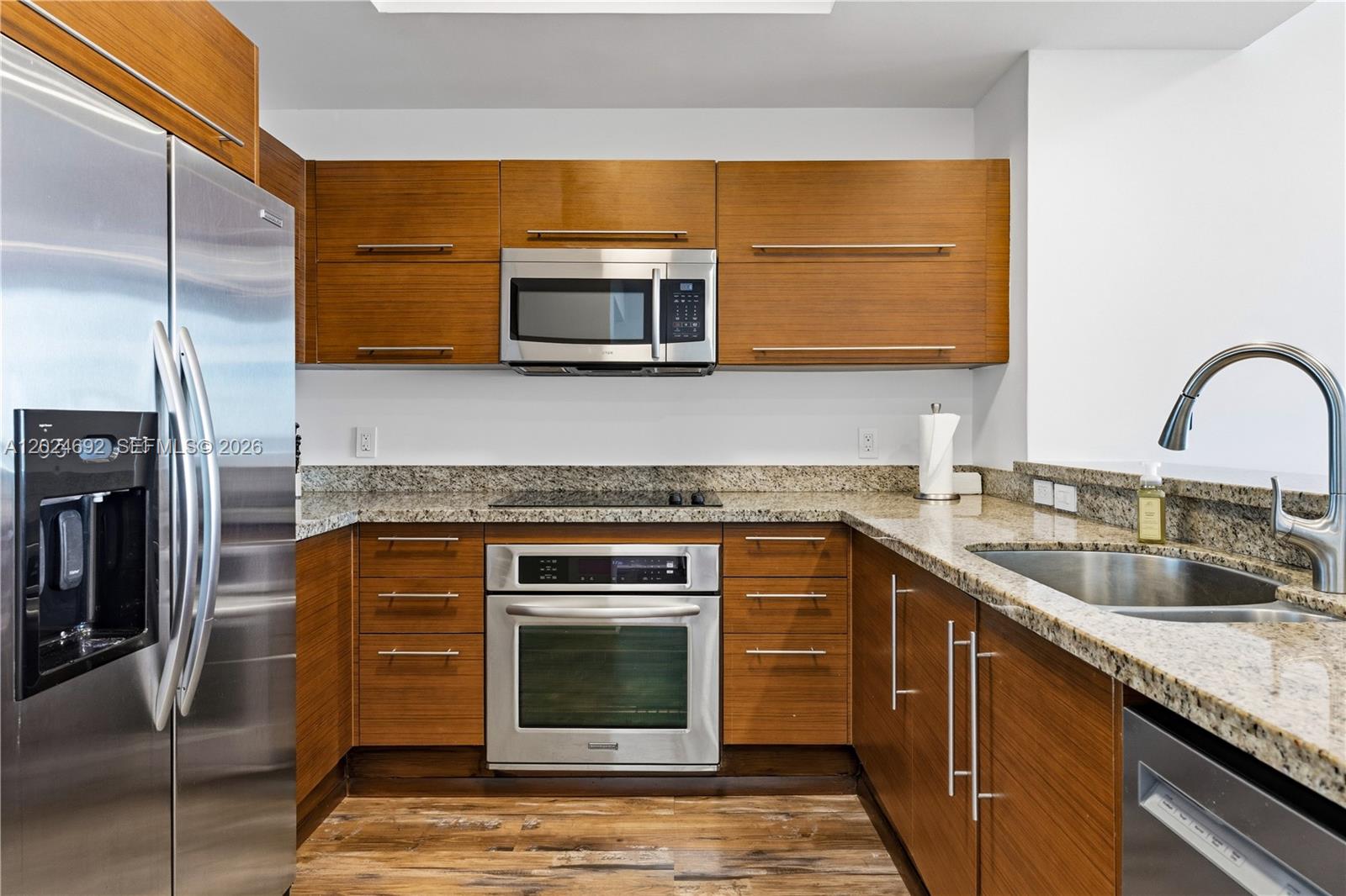 2641 North Flamingo Road, Unit 2605N Sunrise, FL 33323 - Photo 4 of 56 a kitchen with stainless steel appliances granite countertop a sink a stove and microwave