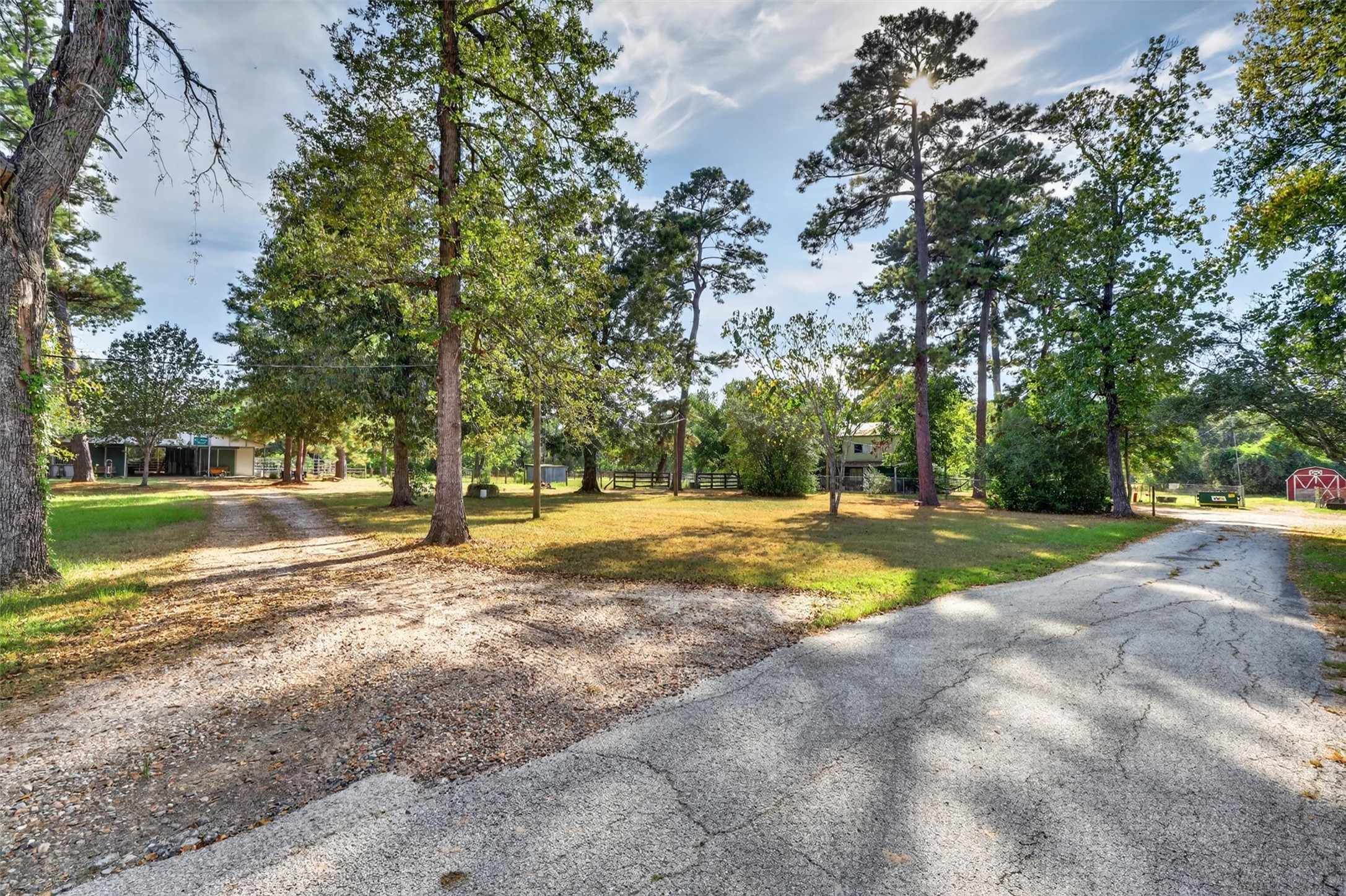 12625 Huffmeister Road Cypress, TX 77429 - Photo 31 of 50 Thoughtfully designed for convenience and functionality, this secondary driveway provides separate access for deliveries and equestrian activities without disturbing the privacy of the main residence. Reinforced to accommodate heavy loads, the driveway leads to a well-equipped horse barn featuring multiple redesigned stalls, a tack room, and a horse washing station. The stalls connect directly to a covered riding arena, while the driveway also provides convenient access to the guest house.