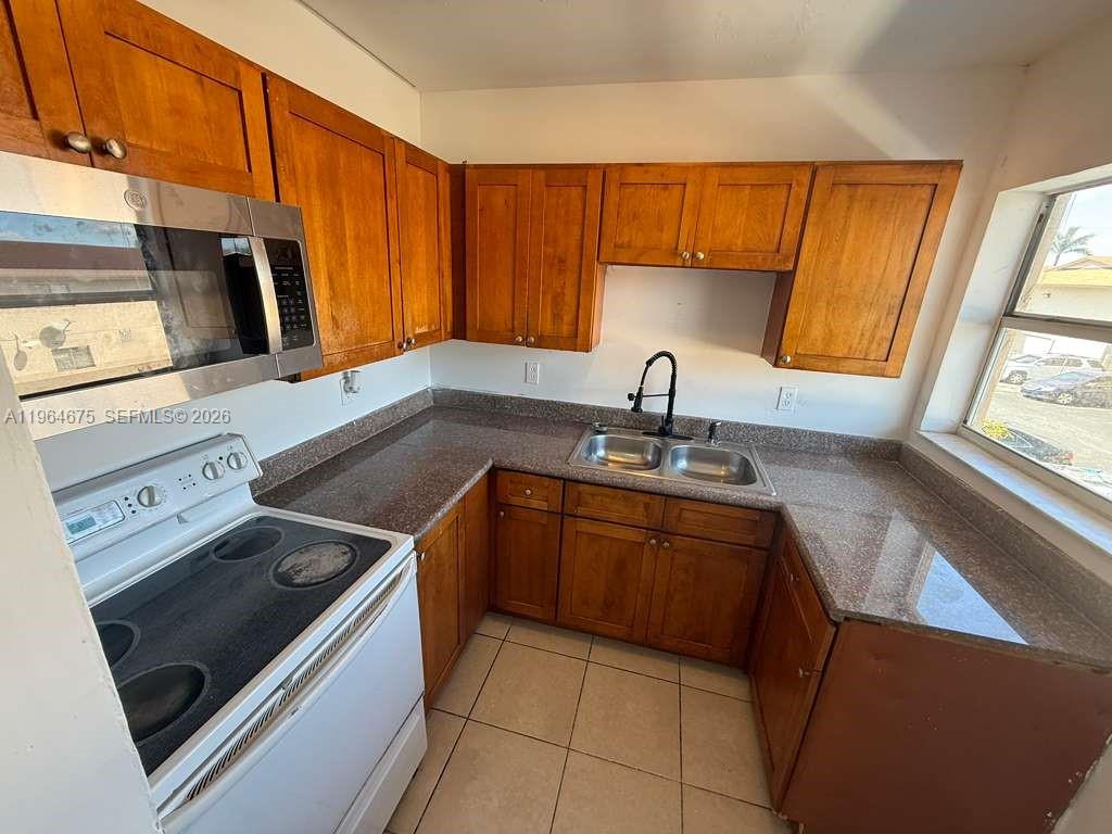 5491 West 24th Avenue, Unit 39 Hialeah, FL 33016 - Photo 11 of 12 a kitchen with stainless steel appliances granite countertop a sink and a stove