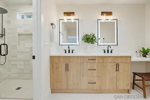 a bathroom with a double vanity sink mirror and shower