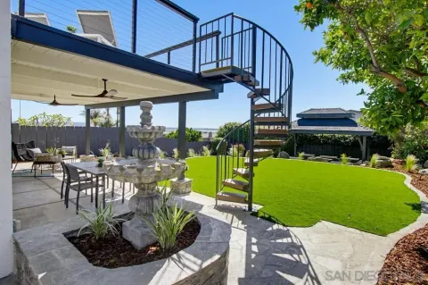 a view of a patio with couches table and chairs under an umbrella