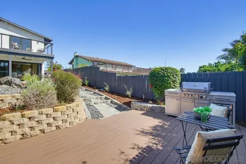 a view of a backyard with chairs potted plants and wooden fence