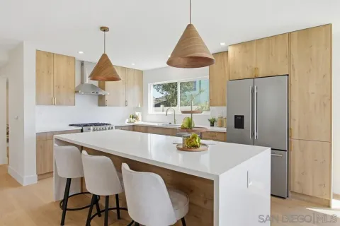 a kitchen with a table chairs and white cabinets