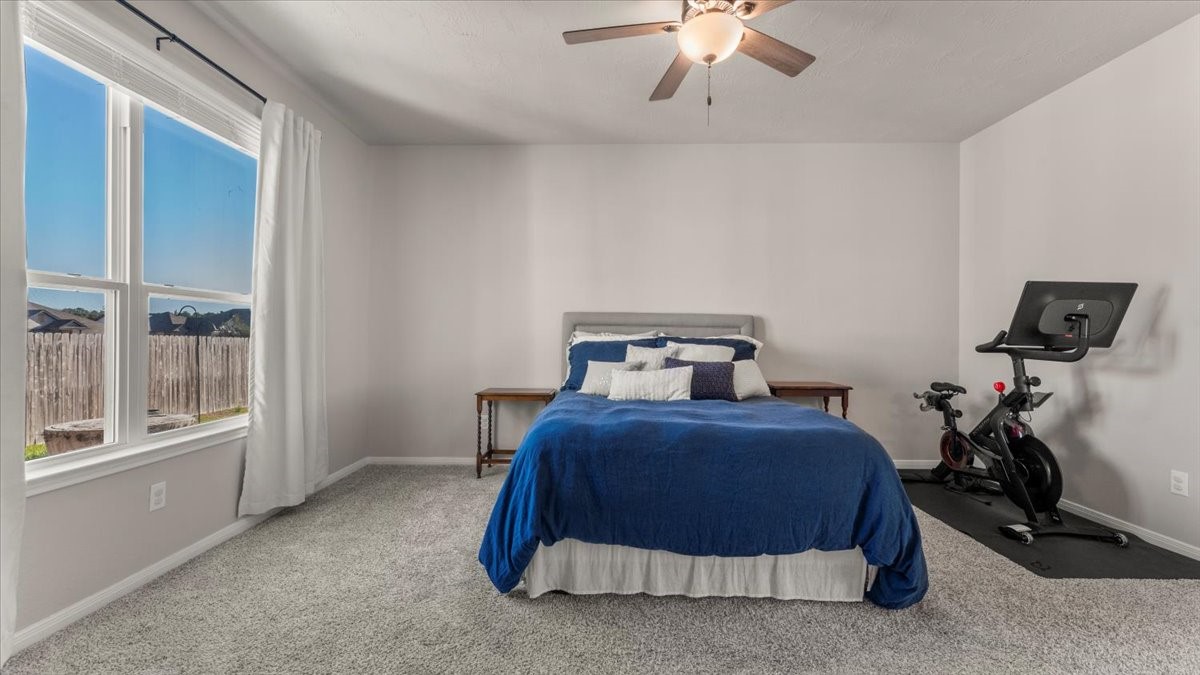 103 Rudder Way Huntsville, TX 77320 - Photo 15 of 35 a bedroom with a bed and a chandelier