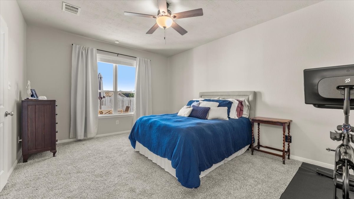 103 Rudder Way Huntsville, TX 77320 - Photo 16 of 35 a bedroom with a bed and a chandelier