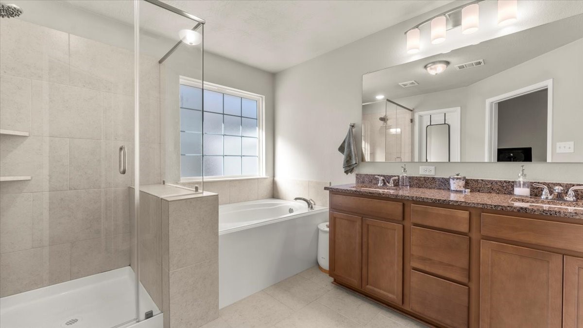 103 Rudder Way Huntsville, TX 77320 - Photo 18 of 35 a bathroom with a double vanity sink mirror and bathtub