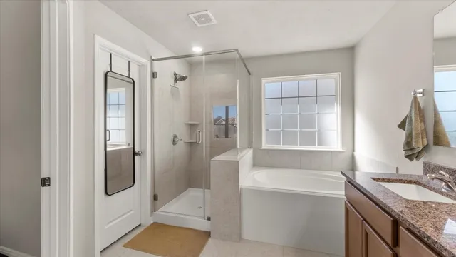 a bathroom with a tub sink and mirror