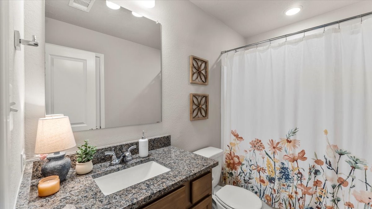 103 Rudder Way Huntsville, TX 77320 - Photo 22 of 35 a bathroom with a granite countertop sink and a mirror