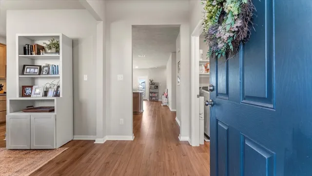 a view of a hallway view with wooden floor and closet