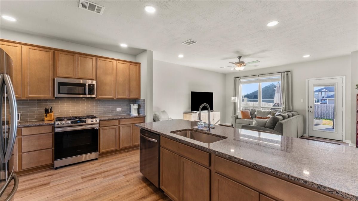 103 Rudder Way Huntsville, TX 77320 - Photo 8 of 35 a kitchen with stainless steel appliances granite countertop a sink dishwasher stove refrigerator and cabinets with wooden floor