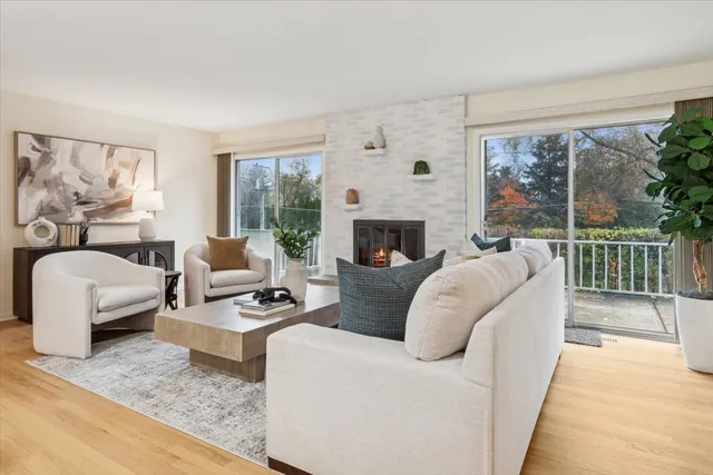 a living room with furniture fireplace and a large window
