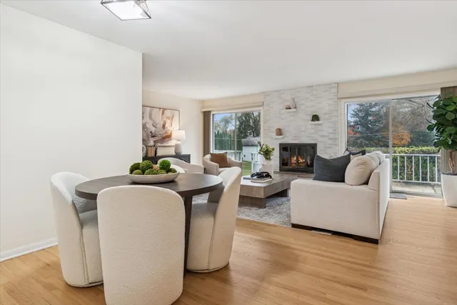 a living room with furniture a fireplace and a floor to ceiling window