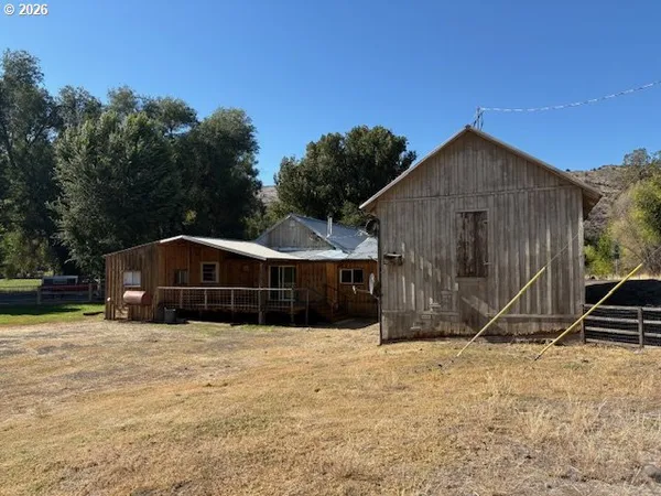 a view of a house with a yard and wooden fence