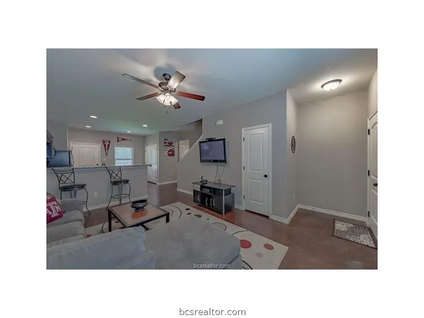 a living room with stainless steel appliances kitchen island furniture and a chandelier
