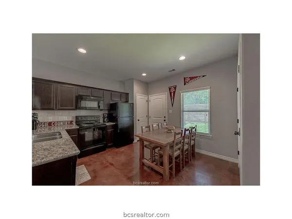a living room with stainless steel appliances kitchen island granite countertop a sink a dining table and chairs