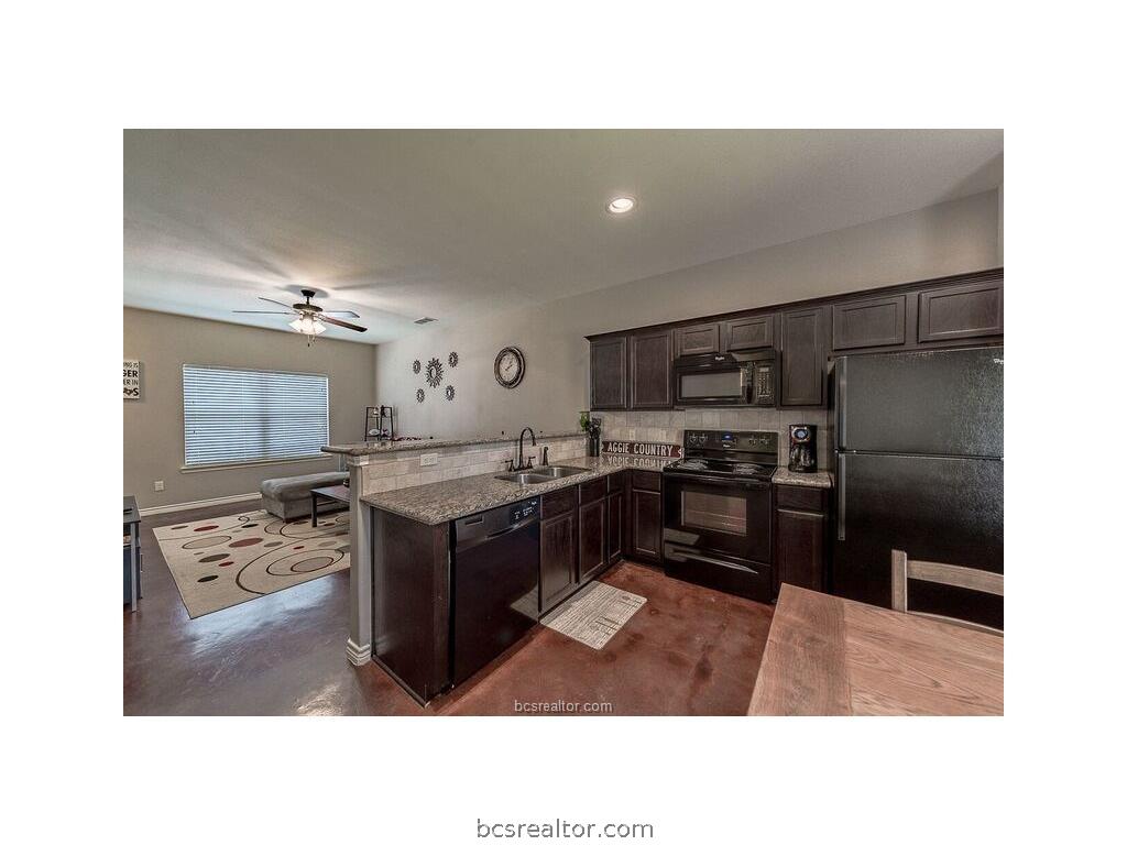 129 Watson Lane Bryan, TX 77801 - Photo 5 of 20 a kitchen with a refrigerator and a sink