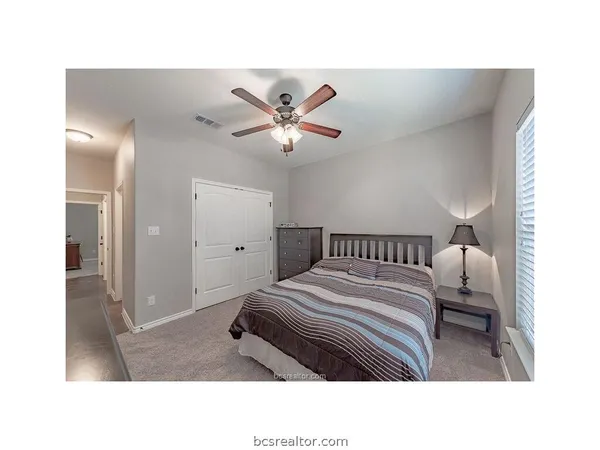 a living room with a bed furniture and a ceiling fan