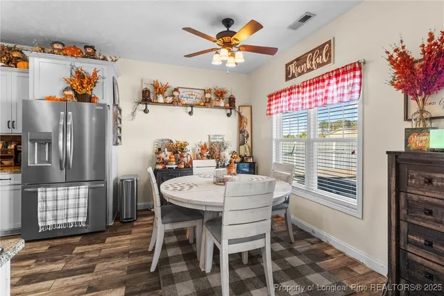 a living room with stainless steel appliances furniture a rug and a kitchen view