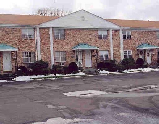 front view of a brick house with a yard