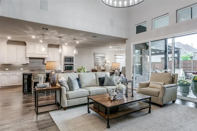 a living room with furniture kitchen view and a large window