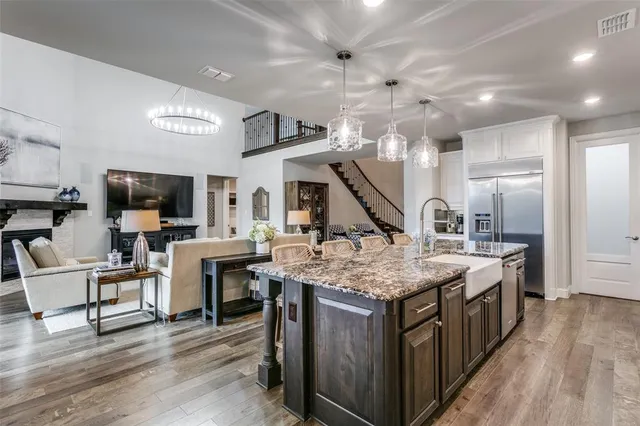 a kitchen that has a lot of cabinets a sink and wooden floor