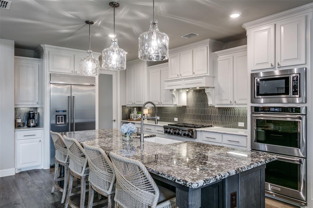 1801 Wichita Drive Prosper, TX 75078 - Photo 20 of 36 a kitchen with stainless steel appliances granite countertop a sink dishwasher a dining table and chairs with wooden floor