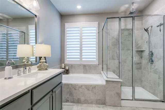 a bathroom with a granite countertop sink a mirror and shower