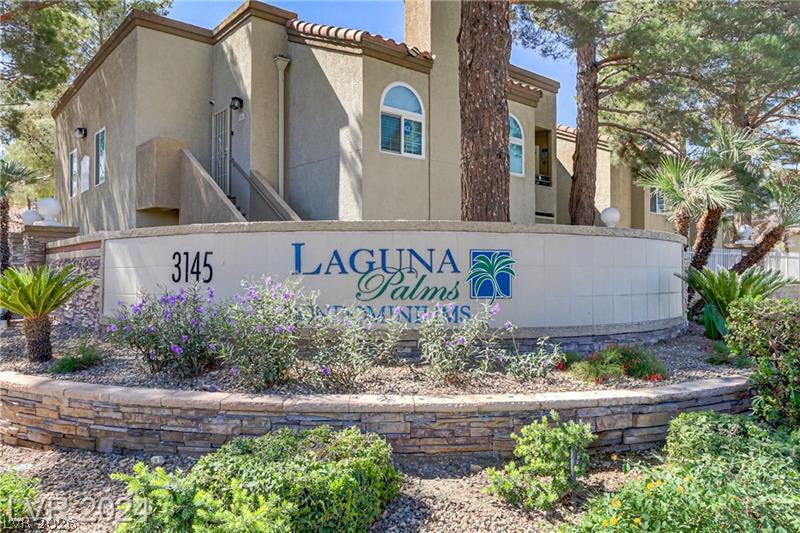 3145 East Flamingo Road, Unit 2129 Las Vegas, NV 89121 - Photo 40 of 43 A welcoming stone-clad sign greets residents to Laguna Palms Condominiums amidst vibrant landscaping.