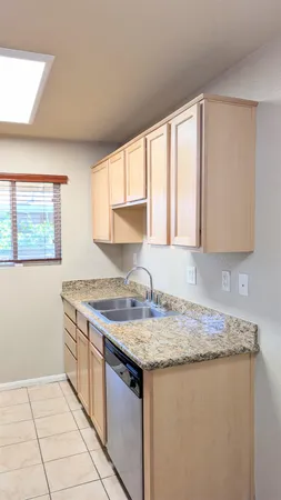 a kitchen with granite countertop a sink stove and cabinets
