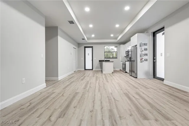a view of a kitchen with refrigerator and white cabinets