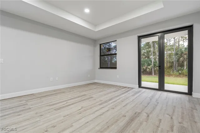 a view of an empty room with glass door and a window