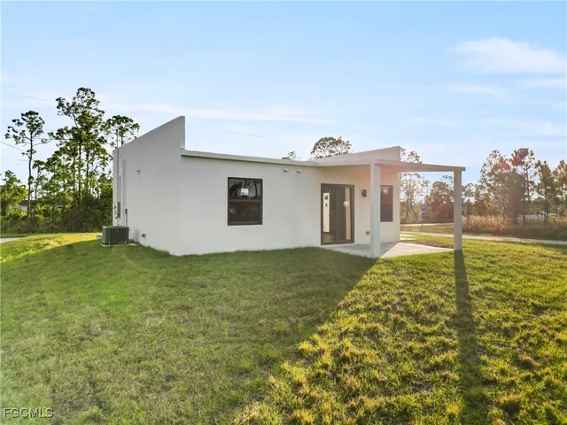 a view of an house with backyard and trees