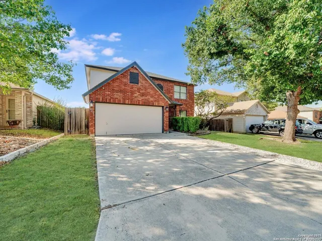 a front view of a house with a garden and trees