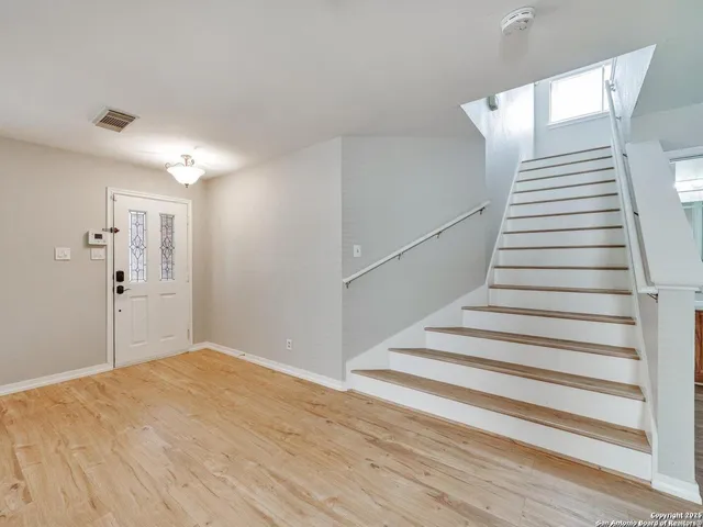 a view of a room with wooden floor and white walls