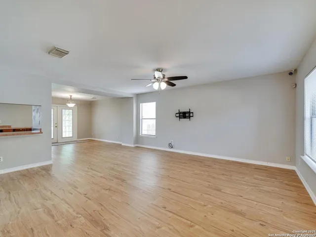 a view of a livingroom with wooden floor and a ceiling fan