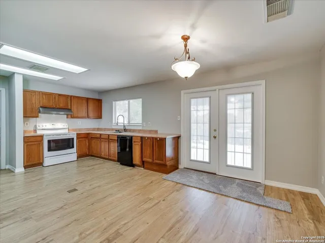 a large kitchen with stainless steel appliances granite countertop a dishwasher cabinets and wooden floor